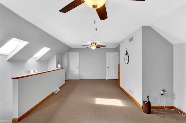 bonus room with lofted ceiling with skylight, carpet, and ceiling fan