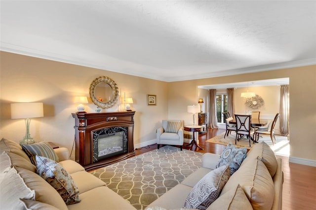 living room with ornamental molding, a fireplace, and hardwood / wood-style flooring