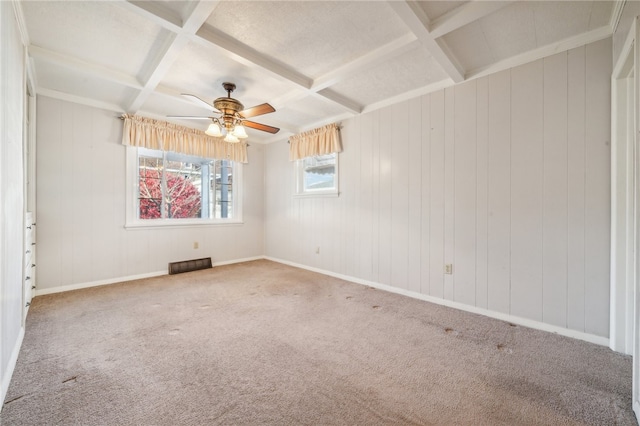 spare room featuring carpet flooring, wooden walls, coffered ceiling, and ceiling fan