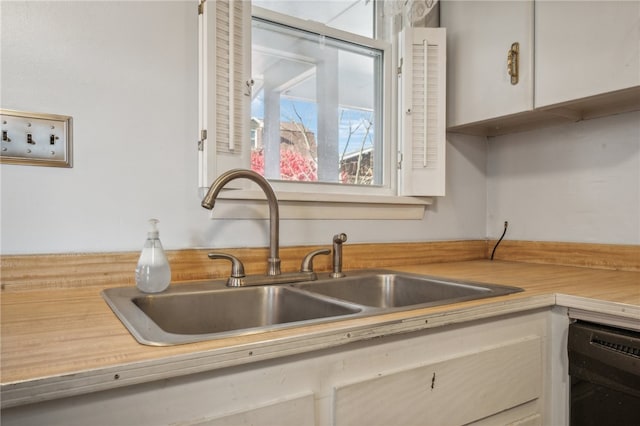 kitchen with sink, white cabinets, and dishwasher