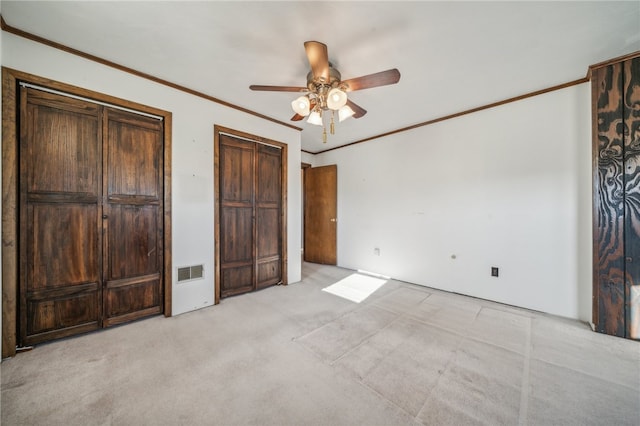 unfurnished bedroom featuring ornamental molding, light carpet, and ceiling fan