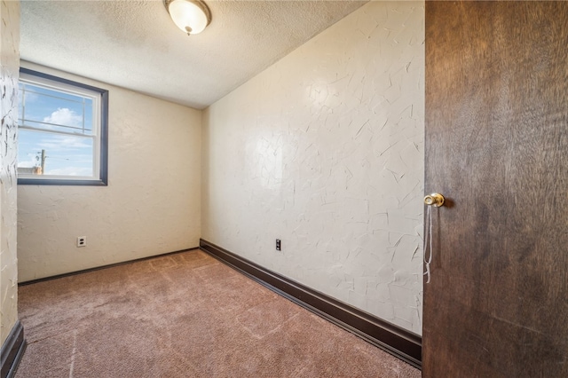 carpeted spare room featuring a textured ceiling and lofted ceiling