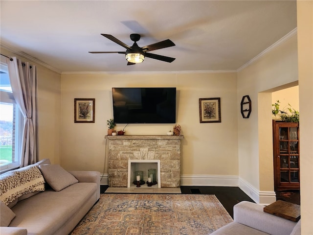 living room featuring ornamental molding, dark hardwood / wood-style floors, a fireplace, and ceiling fan