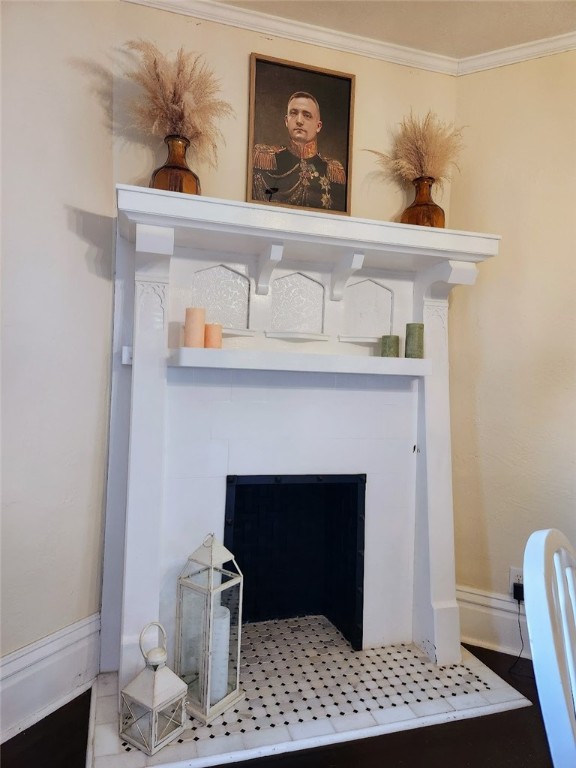 interior details with crown molding and a fireplace