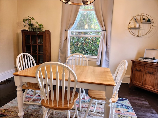 dining space featuring an inviting chandelier and dark hardwood / wood-style flooring