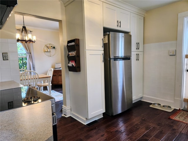 kitchen with appliances with stainless steel finishes, white cabinetry, dark wood-type flooring, and pendant lighting