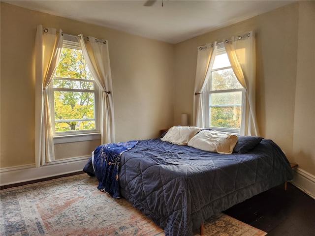 bedroom with hardwood / wood-style floors and multiple windows