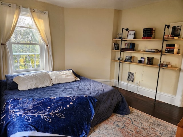 bedroom featuring multiple windows and hardwood / wood-style flooring