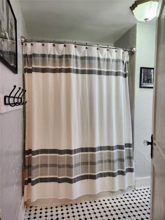 bathroom featuring walk in shower and tile patterned flooring