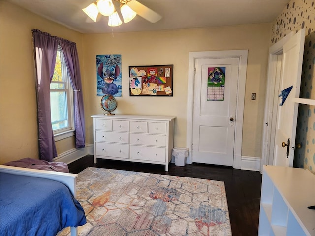 bedroom with dark hardwood / wood-style flooring and ceiling fan