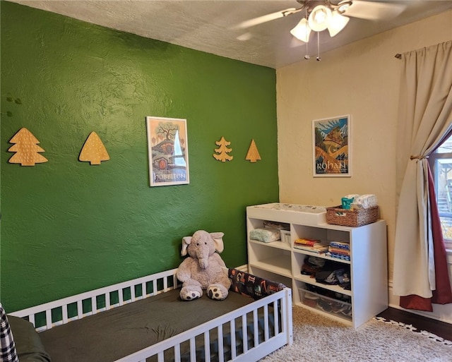 bedroom with a textured ceiling, carpet flooring, and ceiling fan