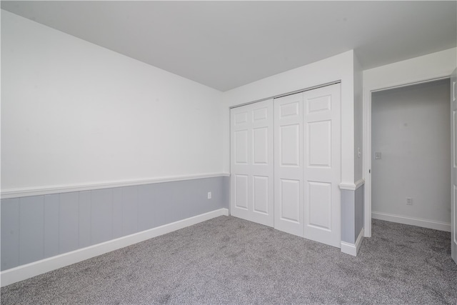 unfurnished bedroom with a closet and carpet flooring