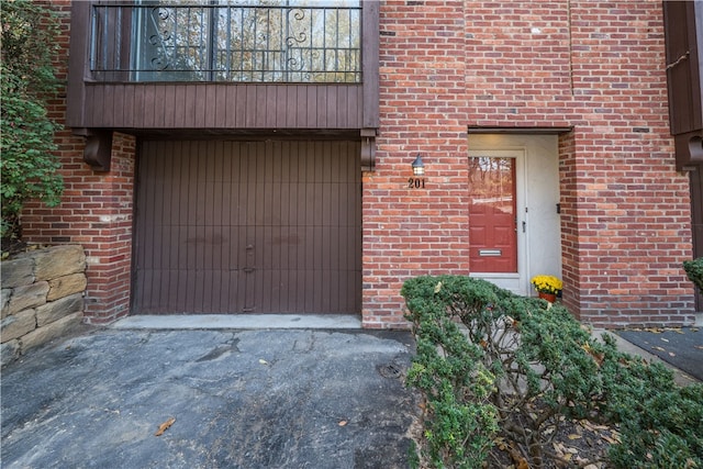 property entrance featuring a balcony and a garage