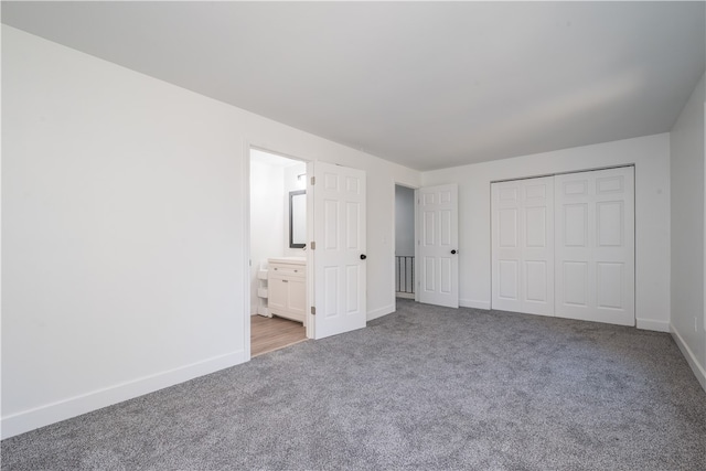 unfurnished bedroom with connected bathroom, carpet flooring, and a closet