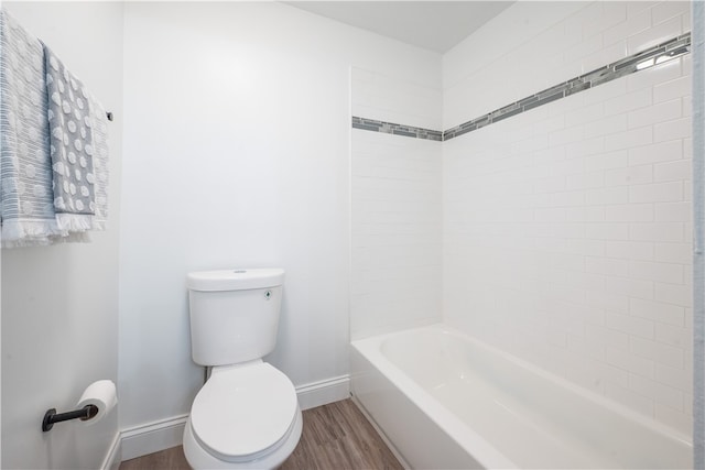 bathroom with toilet, tiled shower / bath combo, and wood-type flooring