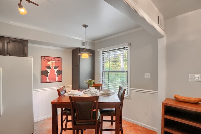 tiled dining room featuring ornamental molding