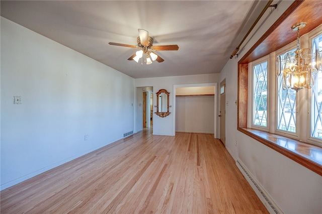 interior space with light wood-type flooring, ceiling fan, and a baseboard radiator