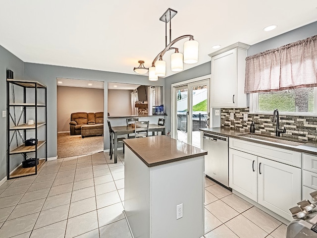 kitchen with dishwasher, a center island, sink, tasteful backsplash, and white cabinetry