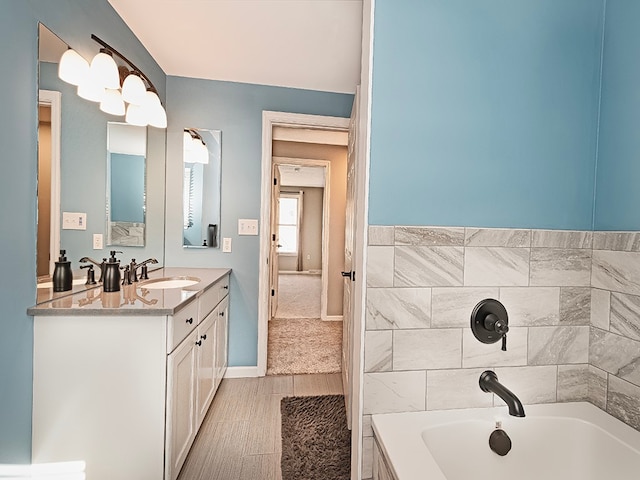 bathroom with a bath, vanity, and hardwood / wood-style flooring