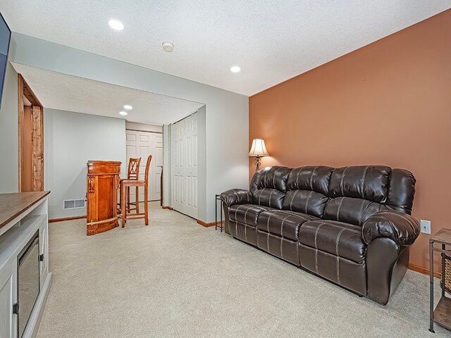 living room with light colored carpet and a textured ceiling