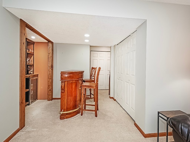 dining space with light colored carpet and a textured ceiling