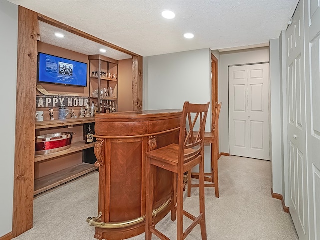 bar with light carpet and a textured ceiling