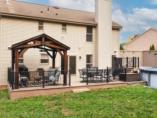 back of house featuring a gazebo, a deck, and a yard