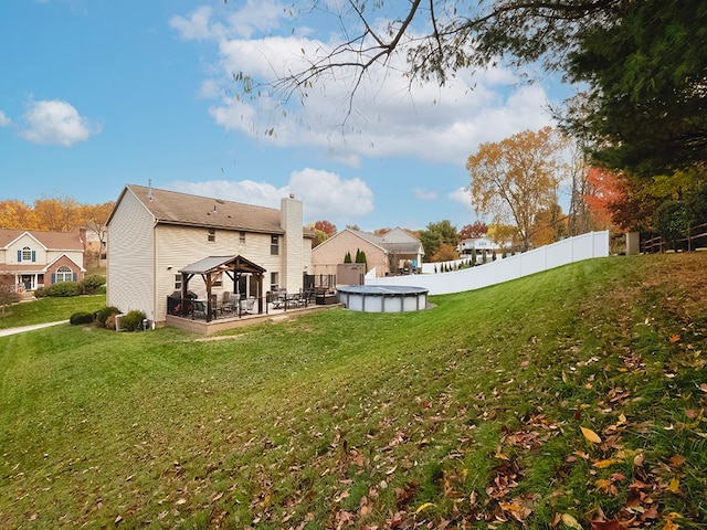 back of house with a gazebo, a lawn, and a covered pool