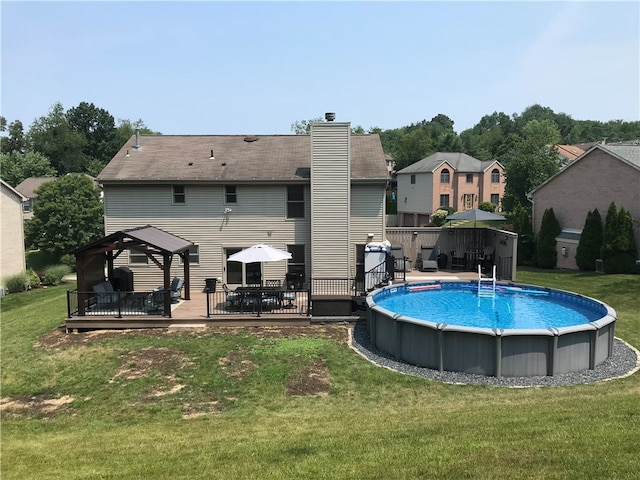 view of pool featuring a lawn, a gazebo, and a wooden deck