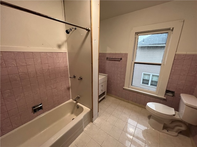 bathroom featuring toilet, bathtub / shower combination, tile patterned floors, and tile walls