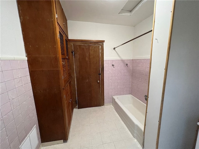 bathroom with tile walls and bathing tub / shower combination