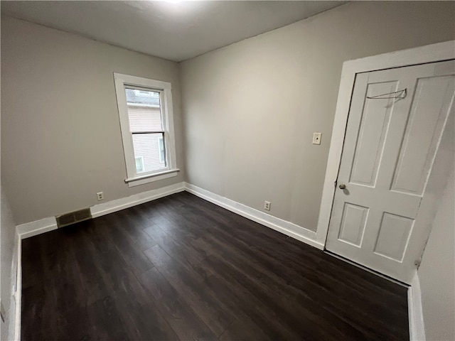 unfurnished room featuring dark wood-type flooring