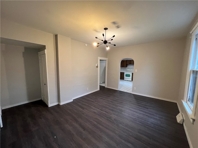 unfurnished living room featuring dark hardwood / wood-style flooring and an inviting chandelier