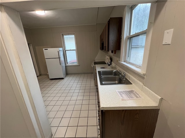 kitchen featuring stainless steel range oven, sink, plenty of natural light, and white refrigerator