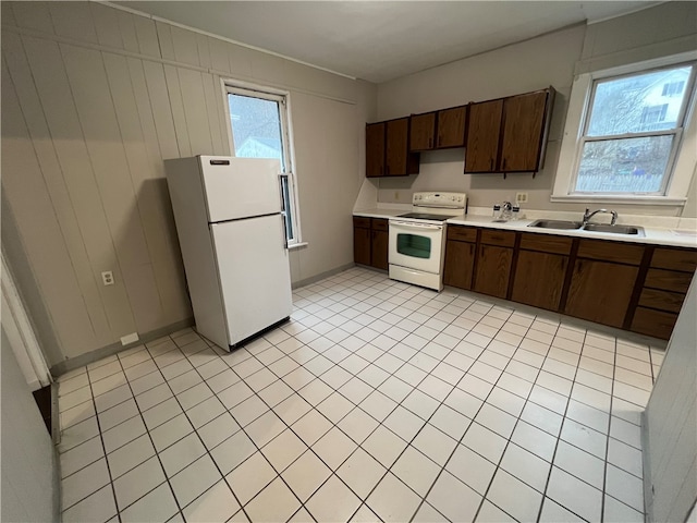 kitchen with white appliances, dark brown cabinetry, and sink