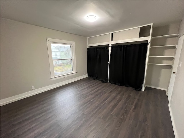 unfurnished bedroom featuring dark wood-type flooring and a closet