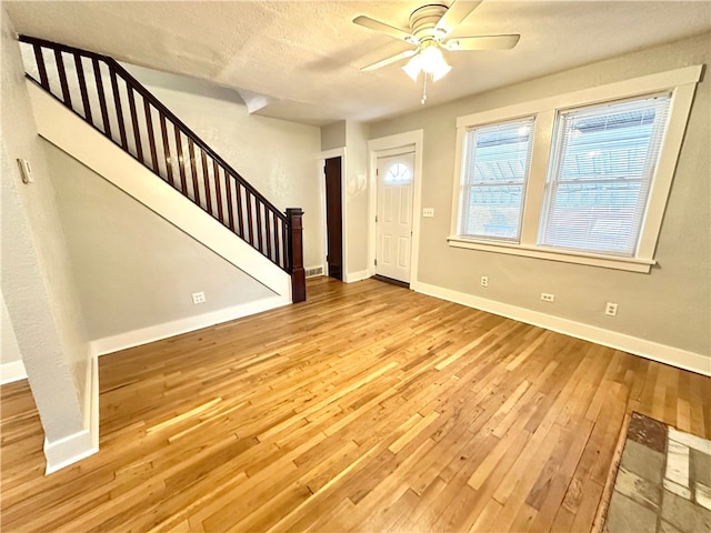 foyer with light hardwood / wood-style flooring, a textured ceiling, and ceiling fan