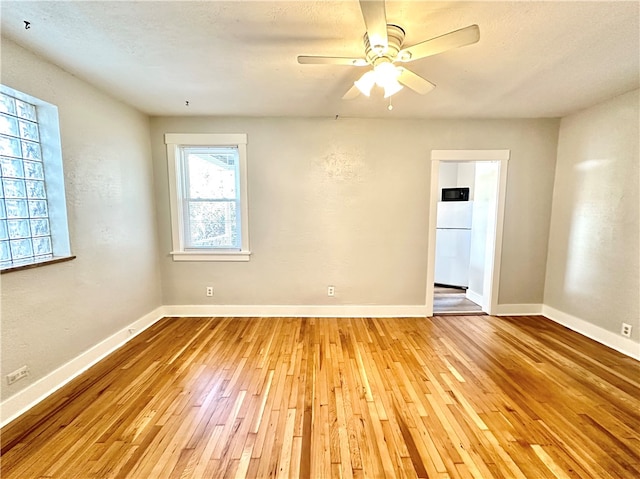 spare room featuring ceiling fan, a textured ceiling, and light wood-type flooring