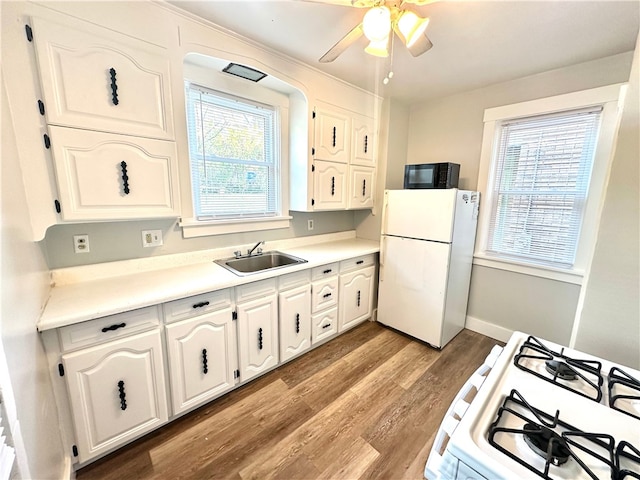 kitchen featuring white appliances, white cabinetry, sink, and plenty of natural light