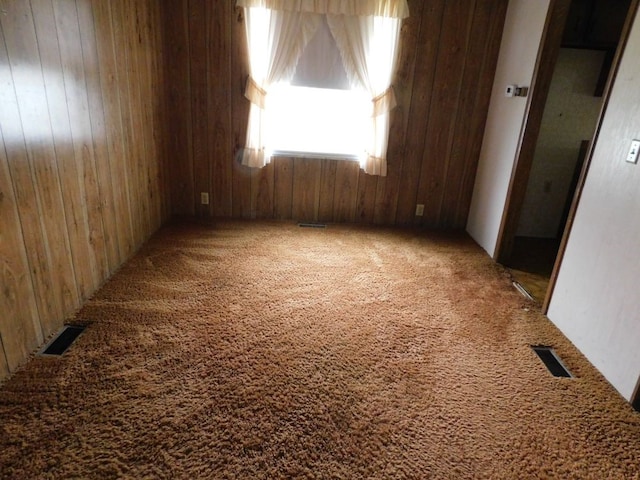 empty room with carpet flooring and wooden walls