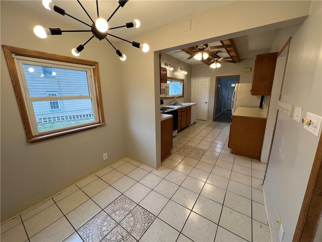 kitchen with light tile patterned floors, beamed ceiling, ceiling fan with notable chandelier, sink, and white appliances