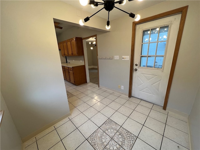 entryway with an inviting chandelier and light tile patterned floors