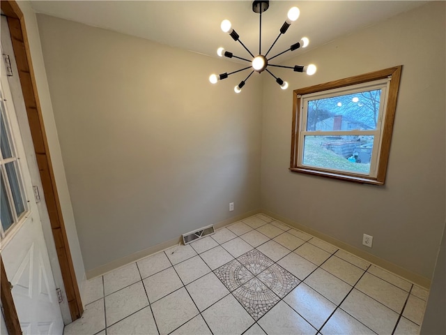 empty room featuring light tile patterned flooring and an inviting chandelier