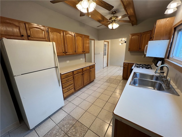 kitchen with white appliances, sink, ceiling fan, beamed ceiling, and light tile patterned floors