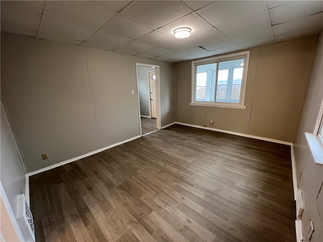 empty room featuring hardwood / wood-style flooring and a drop ceiling