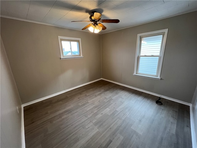 spare room featuring dark wood-type flooring, crown molding, and ceiling fan