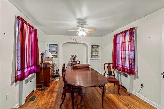 dining room featuring hardwood / wood-style floors, radiator heating unit, and ceiling fan