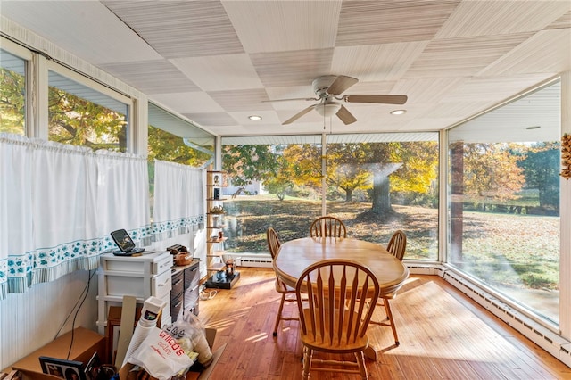 sunroom / solarium featuring ceiling fan, a baseboard radiator, and a wealth of natural light