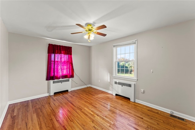 interior space with radiator heating unit, hardwood / wood-style floors, and ceiling fan