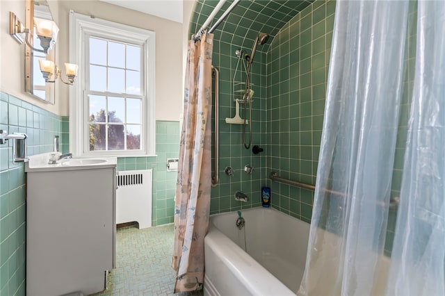 bathroom featuring radiator, tile walls, shower / bath combo with shower curtain, and vanity